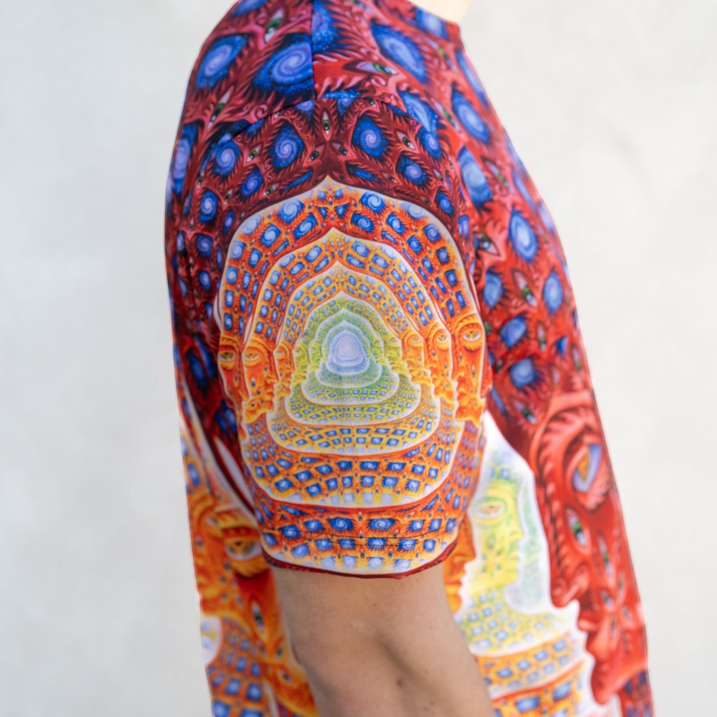 CoSM Shop Net of Being dye-sublimation t-shirt with all-over psychedelic print in red, blue, and yellow.