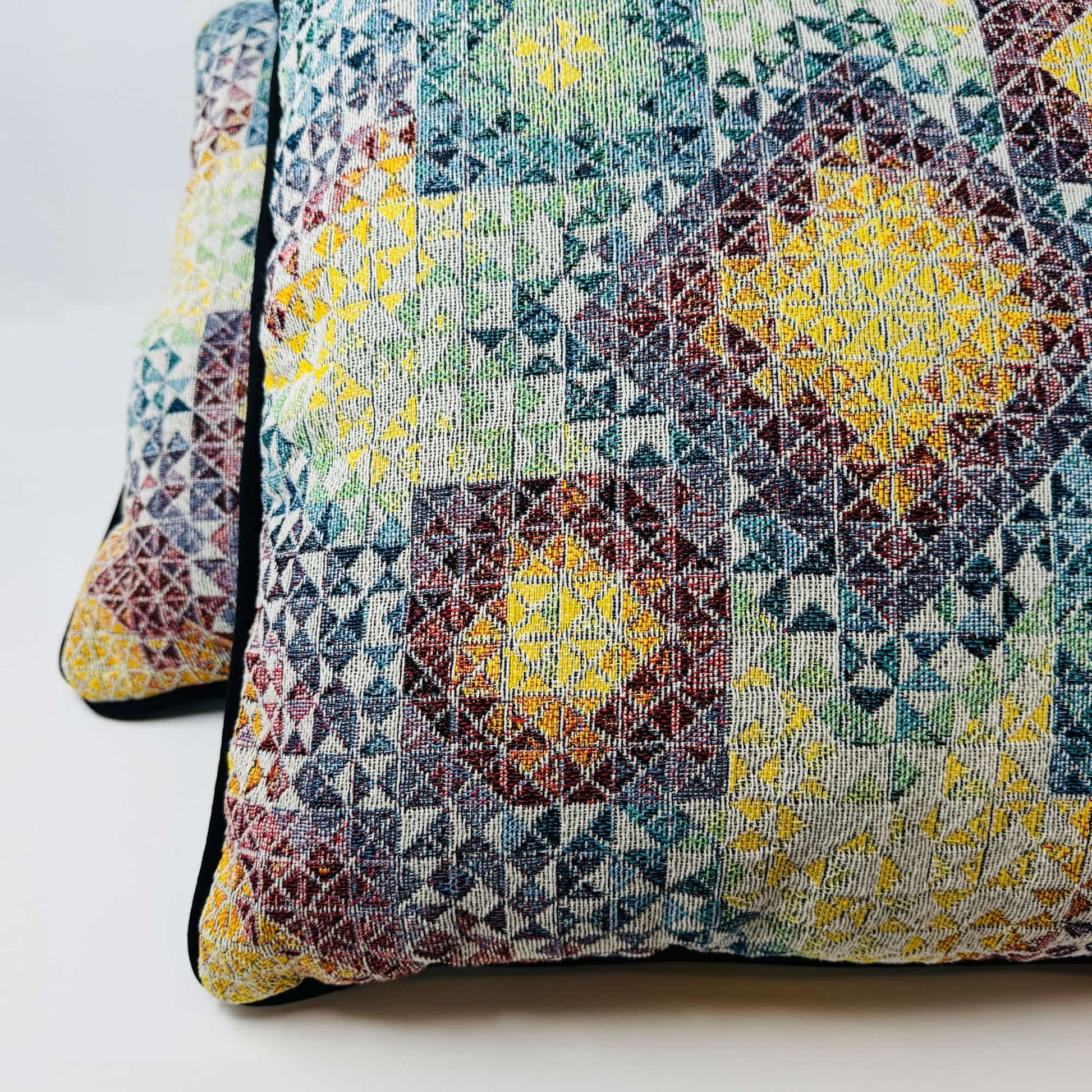 CoSM Shop Gems 3 woven pillow with a colorful geometric pattern in yellow, blue, green, and red. Made from recycled cotton.