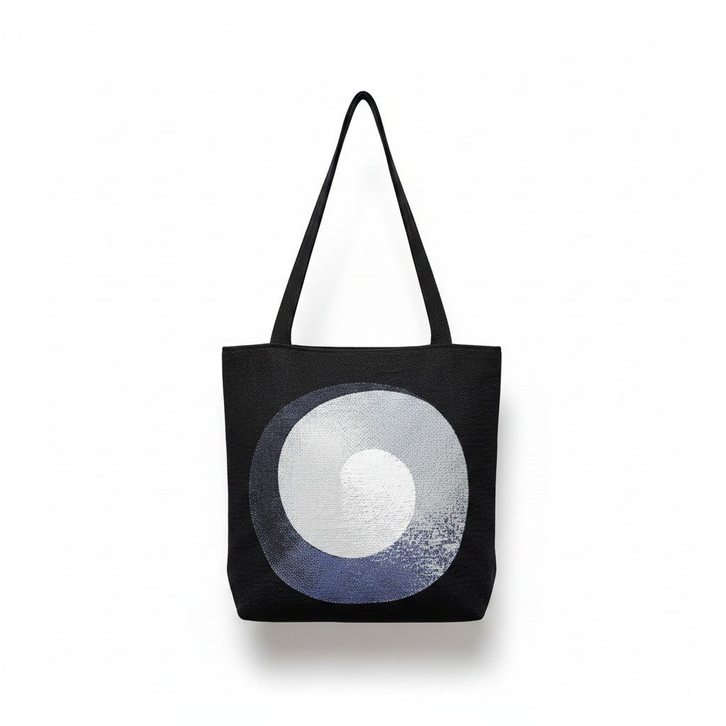 CoSM Shop Polar Unity Spiral woven tote bag with black handles and tapestry art on both sides.