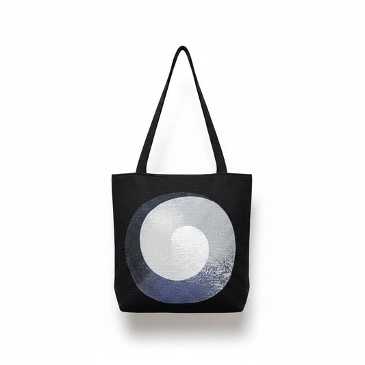 CoSM Shop Polar Unity Spiral woven tote bag with black handles and tapestry art on both sides.