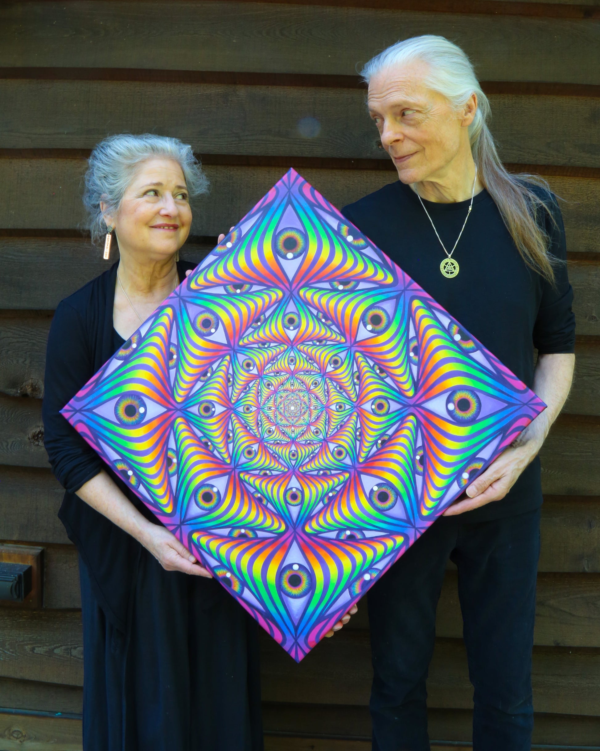 CoSM Shop Rainbow Eye Ripple canvas print featuring a psychedelic fractal pattern of eyes in vibrant rainbow colors, 24x24 inches.