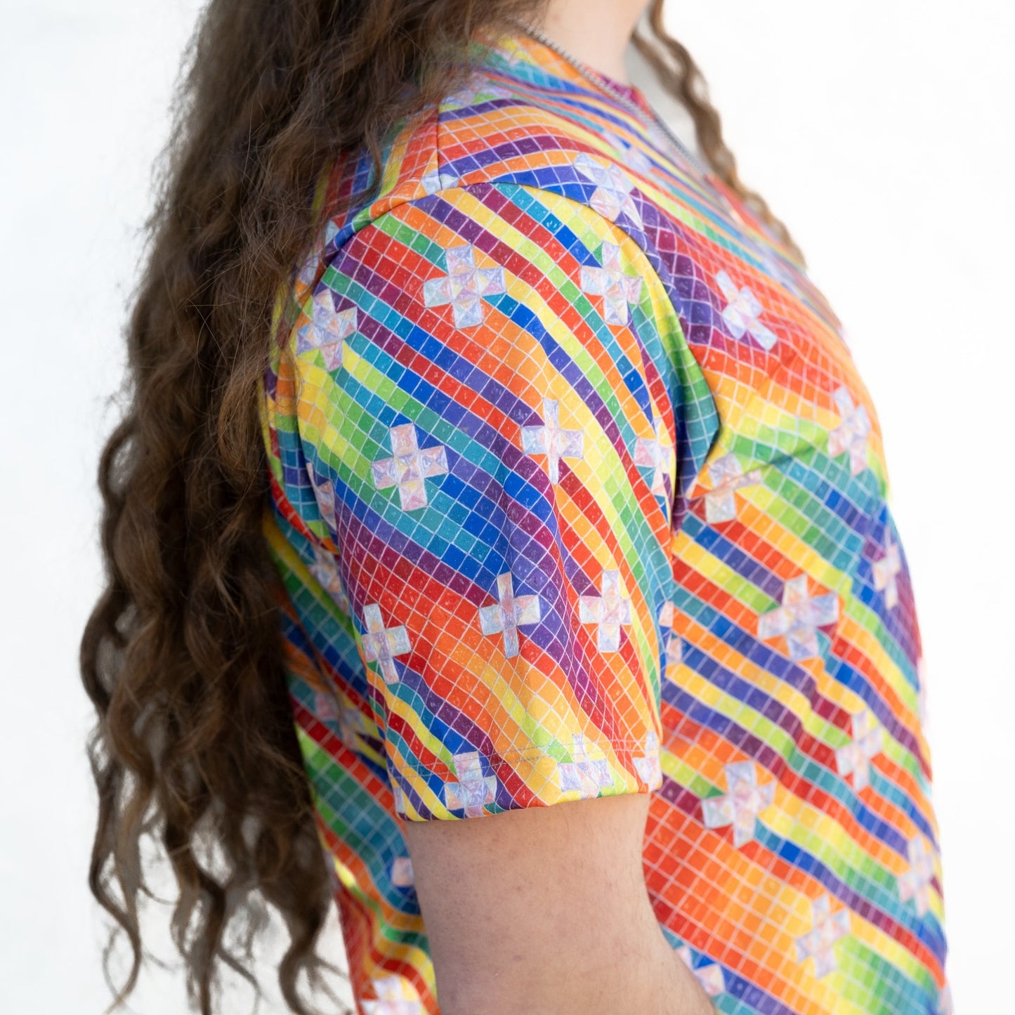 CoSM Shop rainbow tie-dye graphic t-shirt with white cross pattern, made of moisture-wicking polyester for activewear.