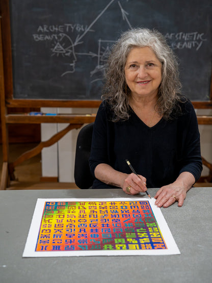 Allyson Grey signs her limited edition Secret Writing Blend paper print, featuring rainbow colors and unique symbols.