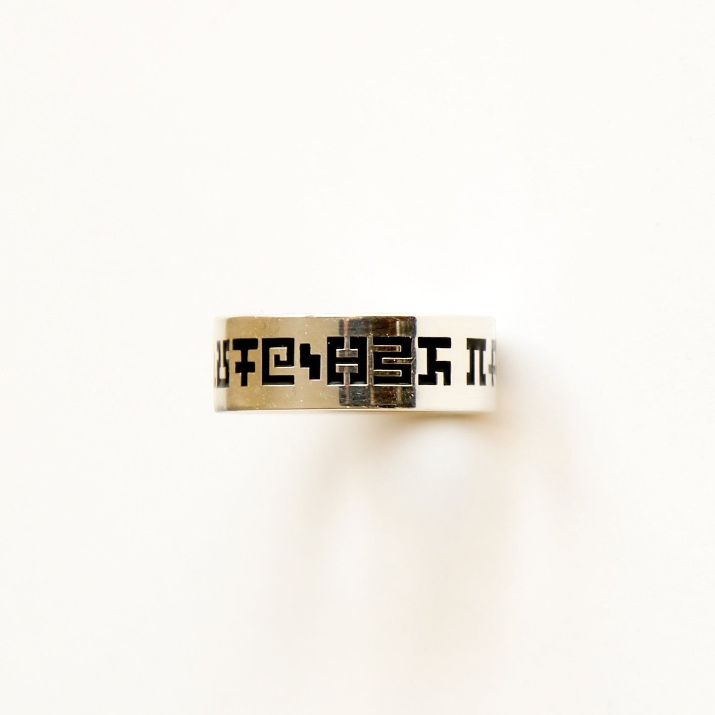 CoSM Shop Secret Writing flat band ring in sterling silver with engraved secret alphabet symbols.