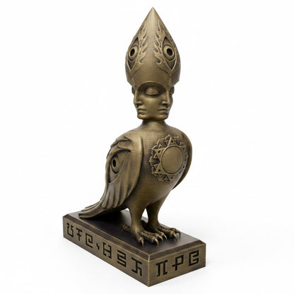 CoSM Shop Soulbird sculpture: a golden, hand-painted bird with a four-faced angel head and eye motifs on wings.